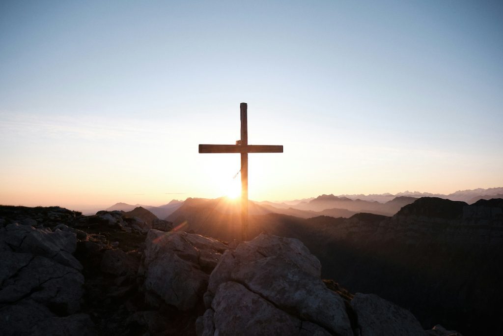 Cross on mountain tops with sunset